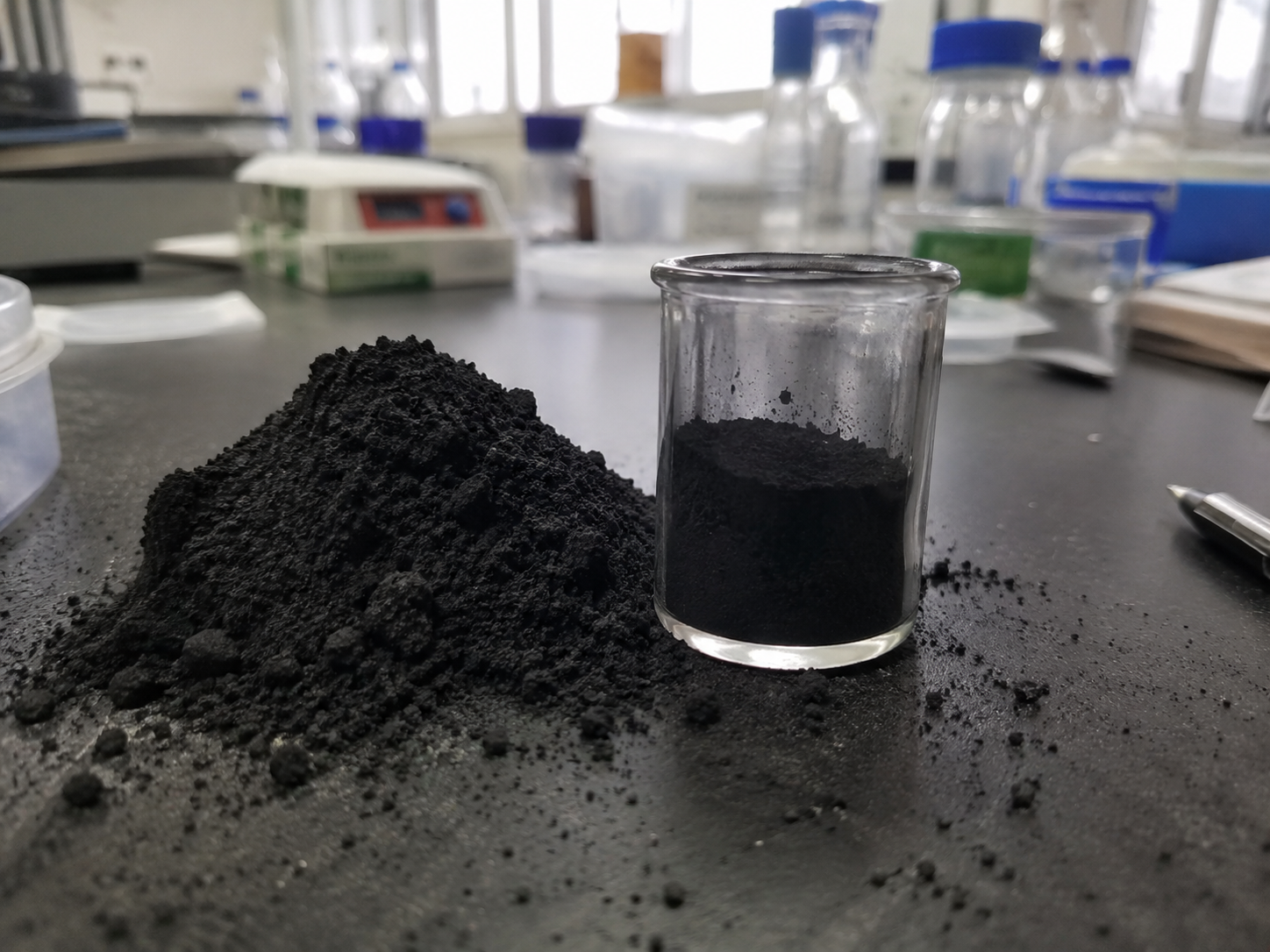 Black mass-prøve på laboratoriebænk med prøveglas